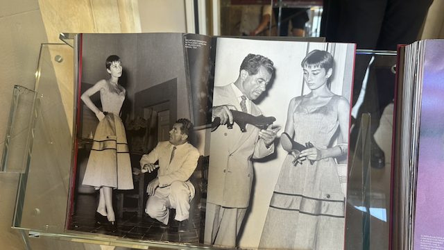 Buchseite mit historischen Fotos von Salvatore Ferragamo bei der Schuhanprobe mit Audrey Hepburn