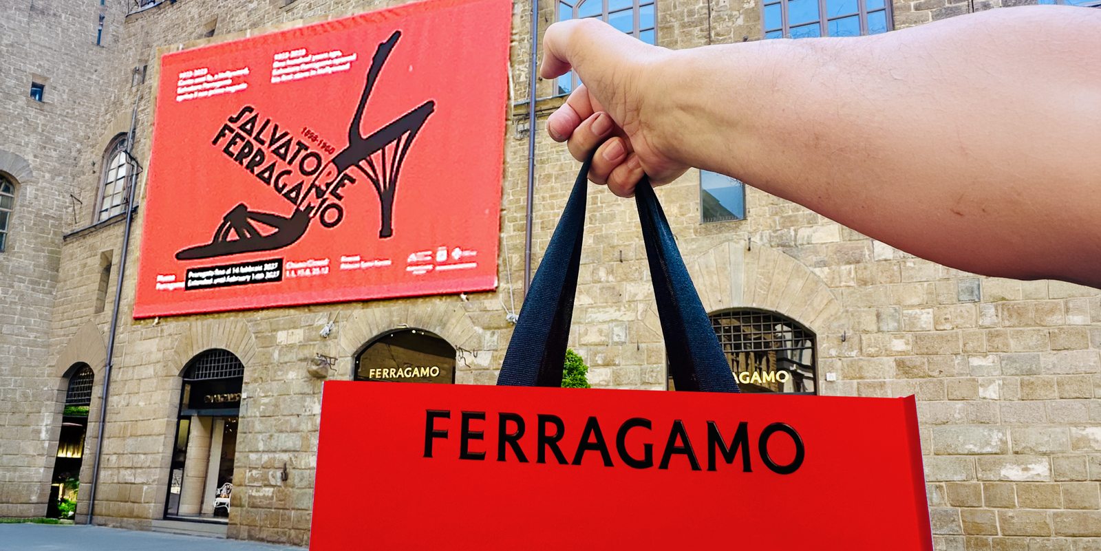Roter Ferragamo-Einkaufsbeutel vor dem Palazzo Spini Feroni in Florenz mit Salvatore-Ferragamo-Ausstellungsplakat