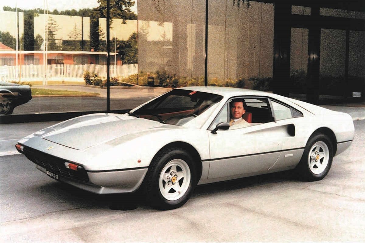 Leonardo Fioravanti am Steuer eines silbernen Ferrari 308 GTB vor dem Pininfarina-Studio