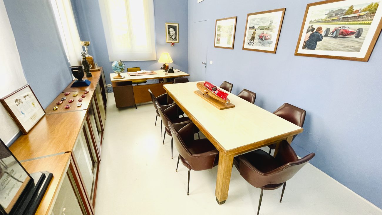 Nachbau von Enzo Ferraris Büro im Museo Enzo Ferrari, Modena, mit Schreibtisch, Konferenztisch und gerahmten Rennbildern